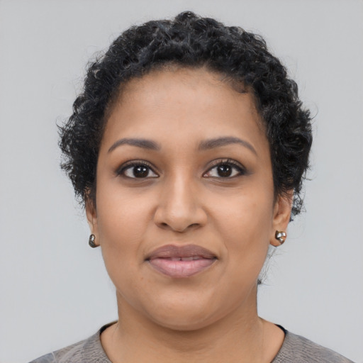 Joyful latino young-adult female with short  black hair and brown eyes