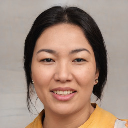 Joyful asian young-adult female with medium  brown hair and brown eyes