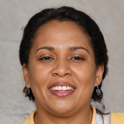 Joyful latino adult female with medium  brown hair and brown eyes