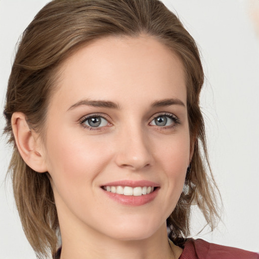 Joyful white young-adult female with medium  brown hair and blue eyes