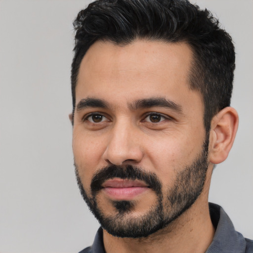 Joyful latino young-adult male with short  black hair and brown eyes