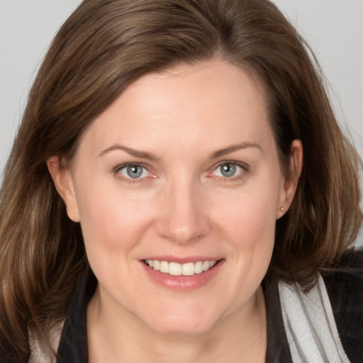 Joyful white adult female with medium  brown hair and grey eyes