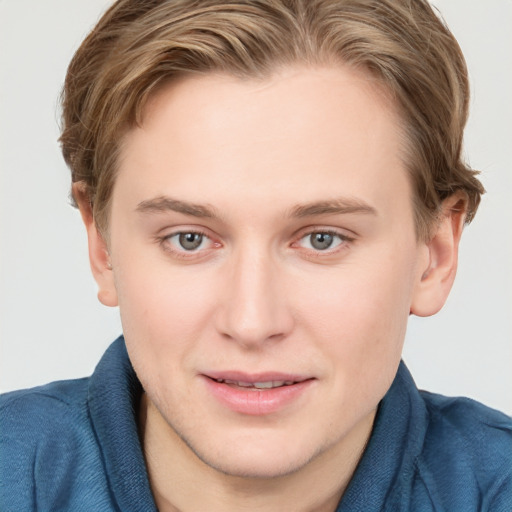 Joyful white young-adult male with short  brown hair and blue eyes