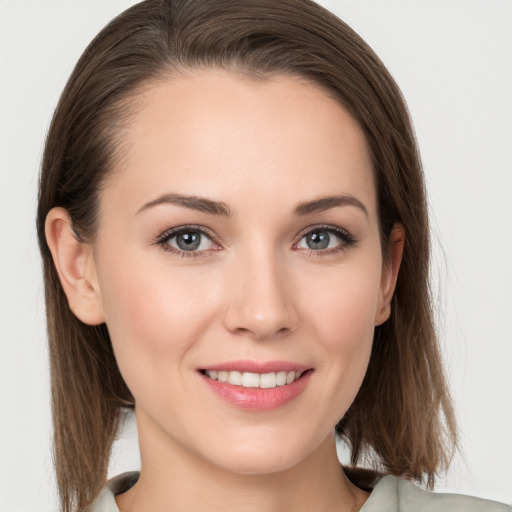 Joyful white young-adult female with medium  brown hair and grey eyes