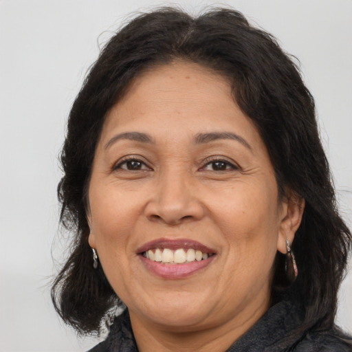 Joyful latino adult female with medium  brown hair and brown eyes