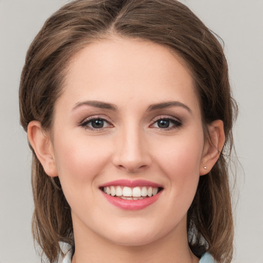 Joyful white young-adult female with medium  brown hair and green eyes