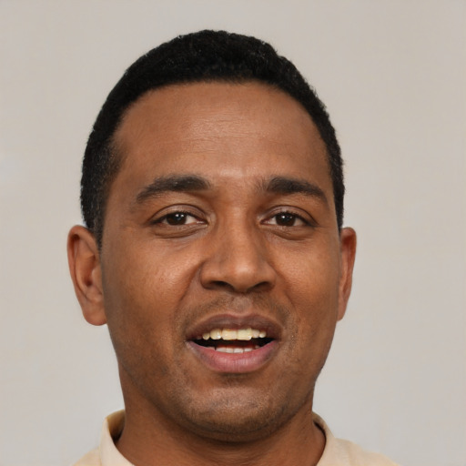 Joyful black young-adult male with short  black hair and brown eyes