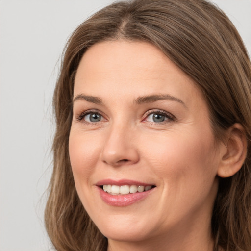 Joyful white young-adult female with long  brown hair and grey eyes