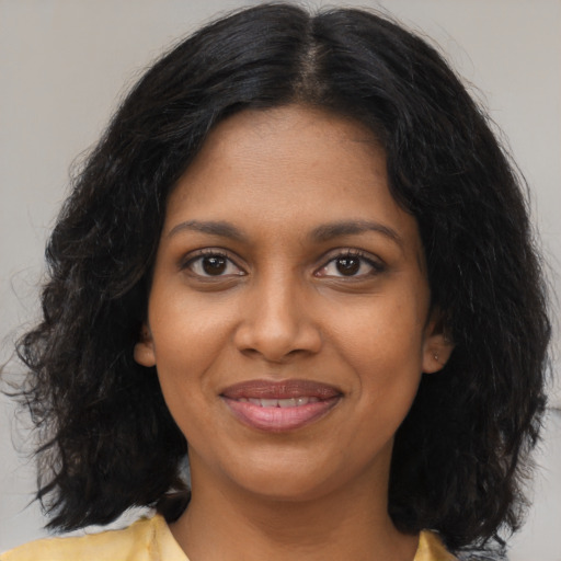 Joyful black young-adult female with medium  brown hair and brown eyes