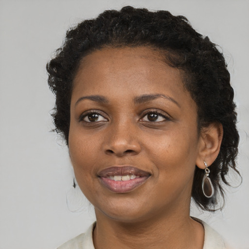 Joyful black young-adult female with medium  black hair and brown eyes