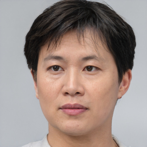 Joyful asian adult male with short  brown hair and brown eyes