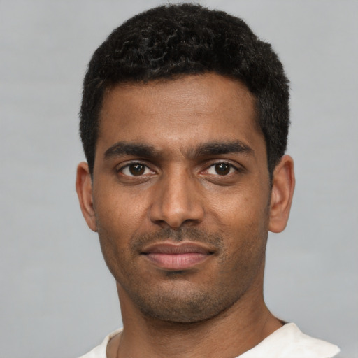 Joyful black young-adult male with short  black hair and brown eyes