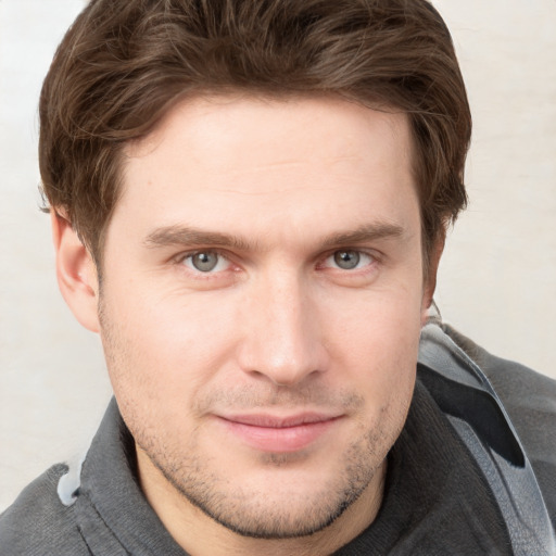 Joyful white young-adult male with short  brown hair and grey eyes