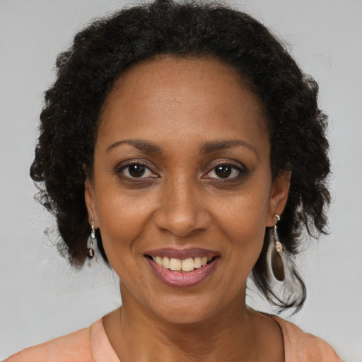 Joyful black adult female with medium  brown hair and brown eyes