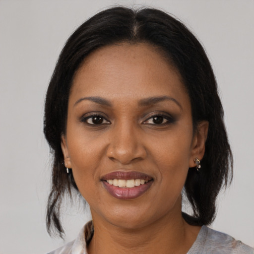 Joyful black young-adult female with medium  brown hair and brown eyes