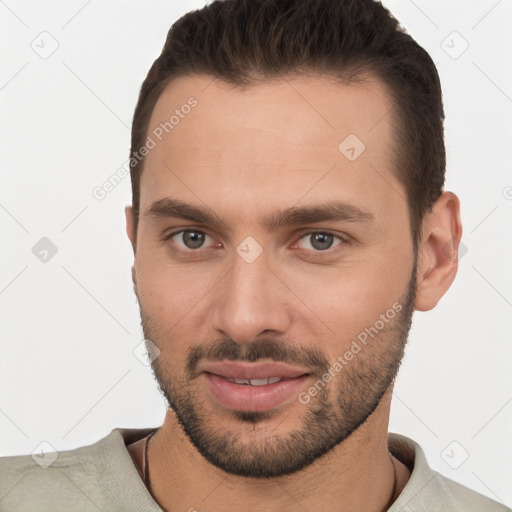 Joyful white young-adult male with short  brown hair and brown eyes