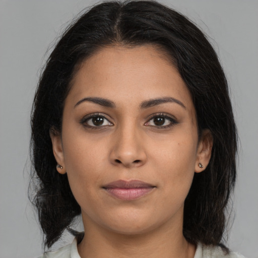 Joyful latino young-adult female with medium  brown hair and brown eyes