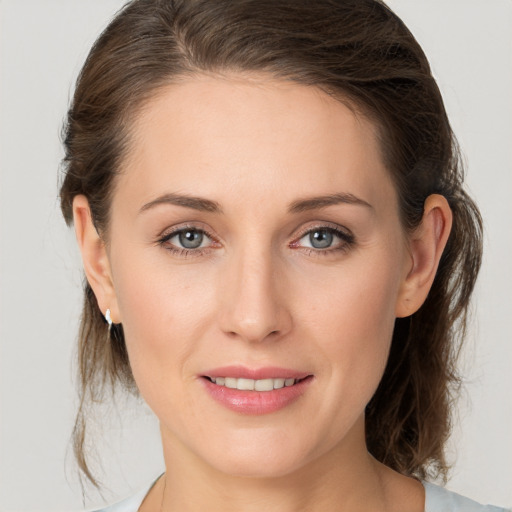 Joyful white young-adult female with medium  brown hair and grey eyes