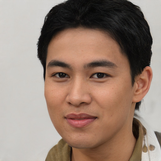 Joyful asian young-adult male with short  brown hair and brown eyes