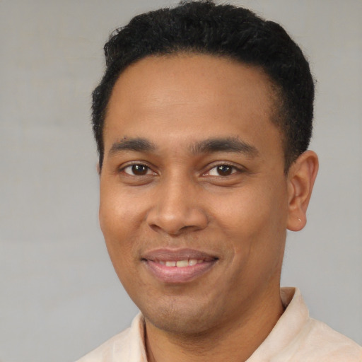 Joyful latino young-adult male with short  black hair and brown eyes