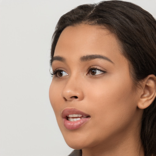 Joyful latino young-adult female with long  brown hair and brown eyes