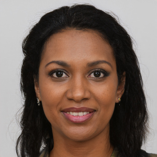 Joyful black young-adult female with long  brown hair and brown eyes