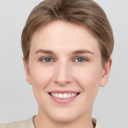 Joyful white young-adult female with short  brown hair and grey eyes