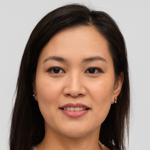 Joyful asian young-adult female with long  brown hair and brown eyes