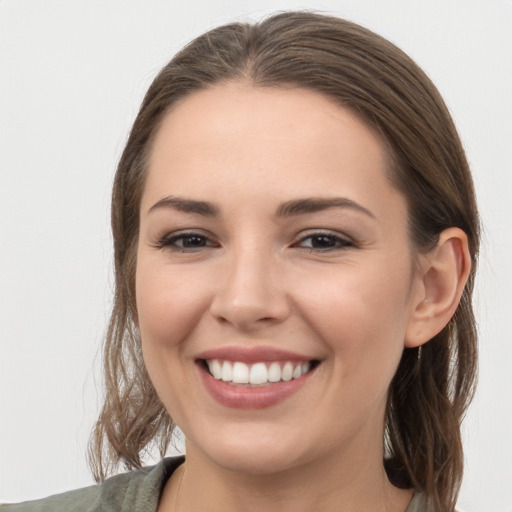 Joyful white young-adult female with medium  brown hair and grey eyes