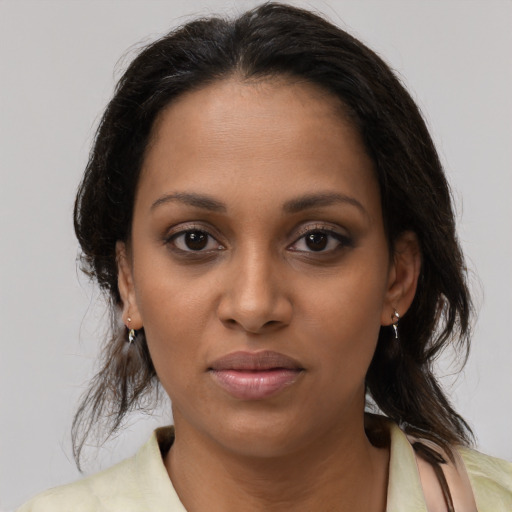 Joyful black young-adult female with medium  brown hair and brown eyes