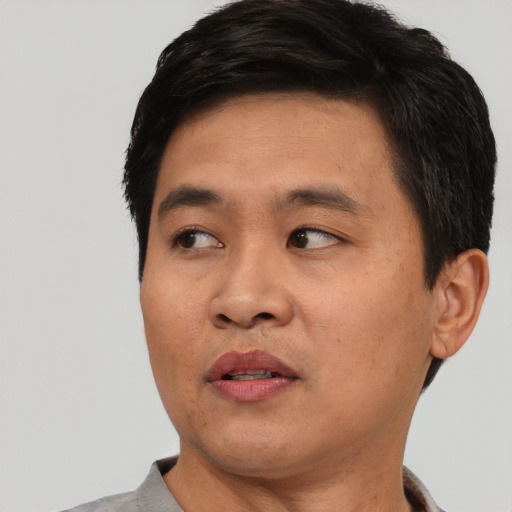 Joyful asian young-adult male with short  black hair and brown eyes