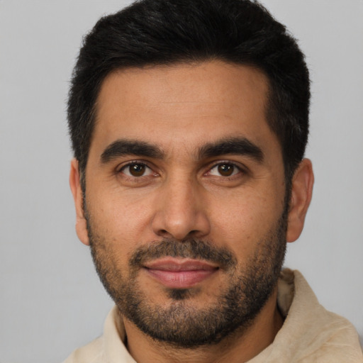 Joyful latino young-adult male with short  black hair and brown eyes