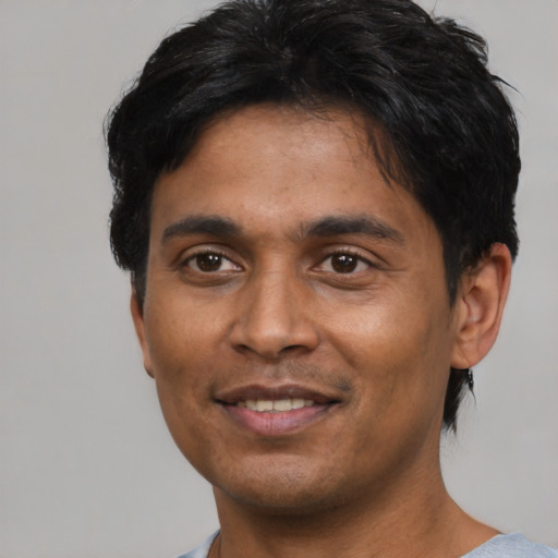 Joyful latino young-adult male with short  black hair and brown eyes