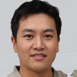 Joyful asian young-adult male with short  brown hair and brown eyes