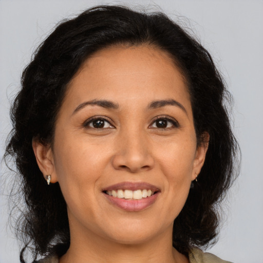 Joyful latino young-adult female with medium  brown hair and brown eyes