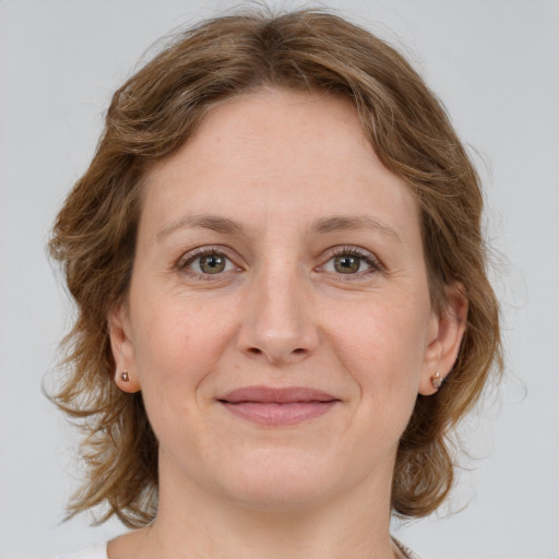 Joyful white adult female with medium  brown hair and green eyes