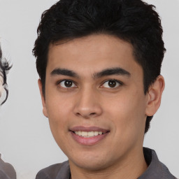 Joyful latino young-adult male with short  brown hair and brown eyes