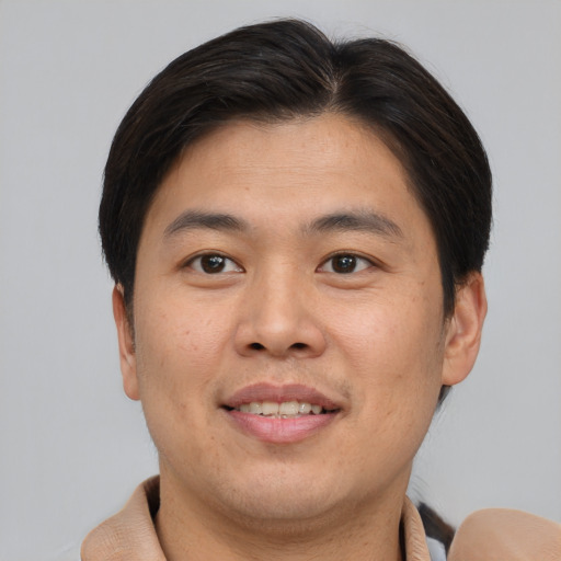 Joyful asian young-adult male with short  brown hair and brown eyes