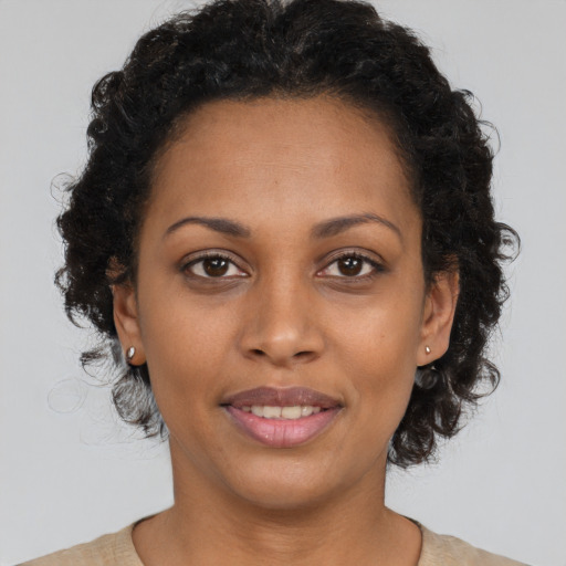 Joyful black young-adult female with medium  brown hair and brown eyes