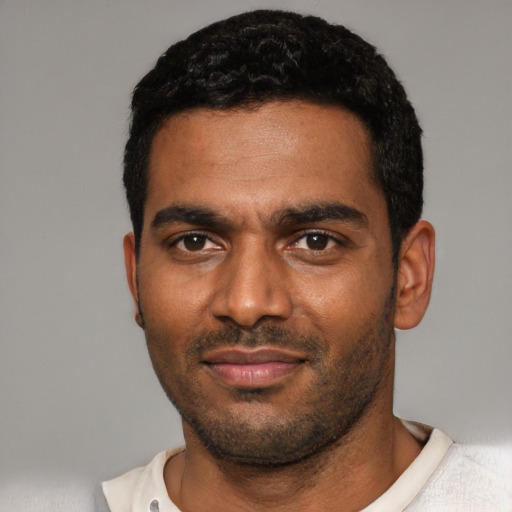 Joyful black young-adult male with short  black hair and brown eyes