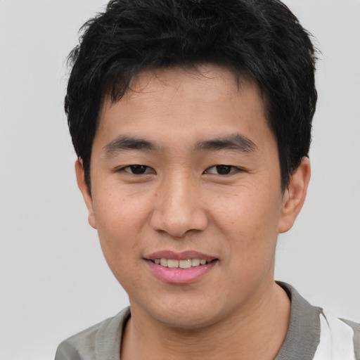Joyful asian young-adult male with short  black hair and brown eyes