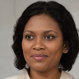 Joyful black adult female with medium  brown hair and brown eyes