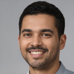 Joyful latino young-adult male with short  black hair and brown eyes