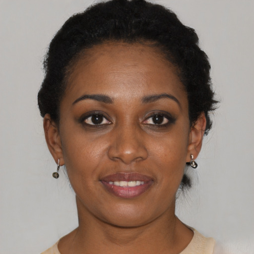 Joyful black young-adult female with short  black hair and brown eyes