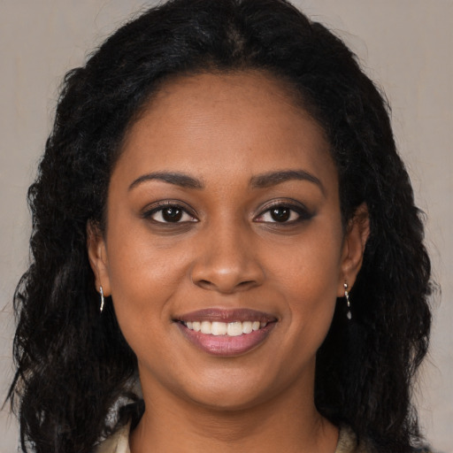 Joyful black young-adult female with long  brown hair and brown eyes