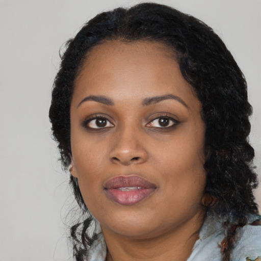 Joyful black young-adult female with long  black hair and brown eyes