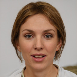 Joyful white young-adult female with medium  brown hair and grey eyes