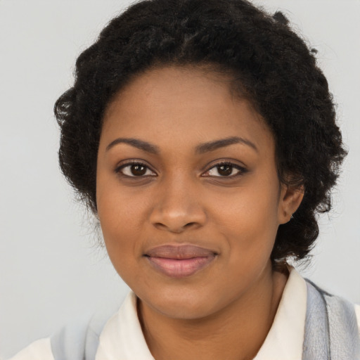 Joyful black young-adult female with long  brown hair and brown eyes