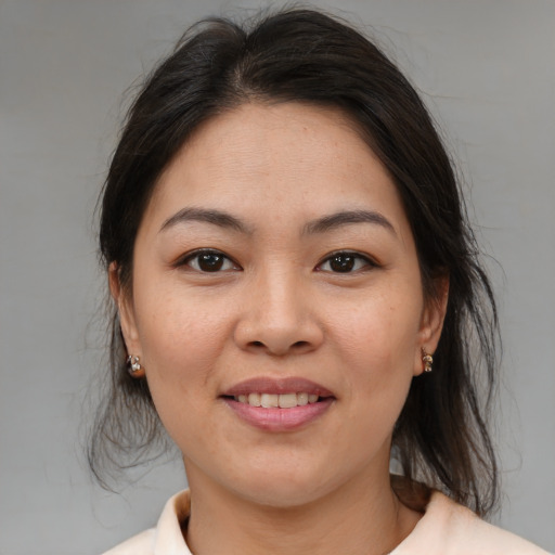 Joyful asian adult female with medium  brown hair and brown eyes