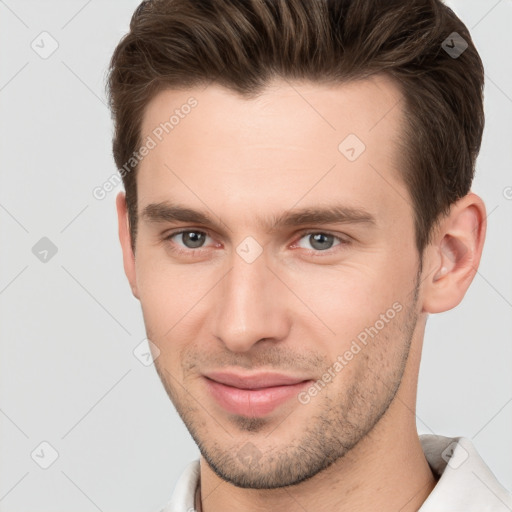 Joyful white young-adult male with short  brown hair and brown eyes